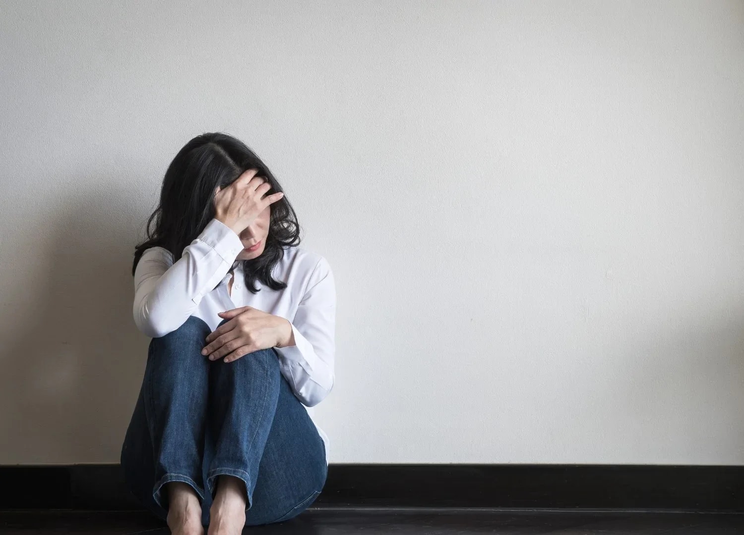 Mulher em momento de ansiedade levando a mão à têmpora, retrato dos sintomas do transtorno