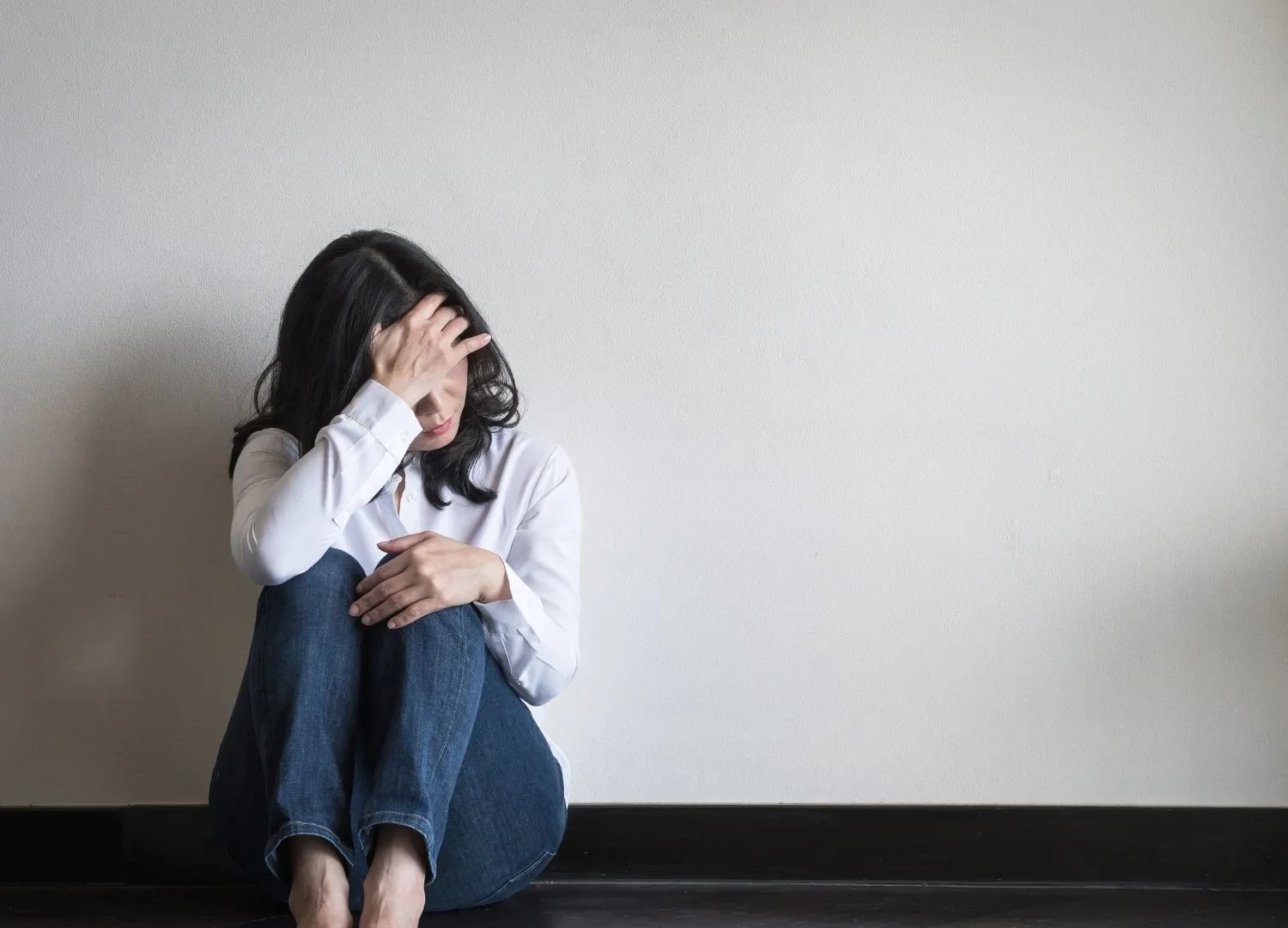 Mulher em momento de ansiedade levando a mão à têmpora, retrato dos sintomas do transtorno